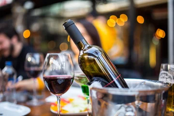 Rolgordijnen rode wijn in een glas en fles met ijsemmer © filiz
