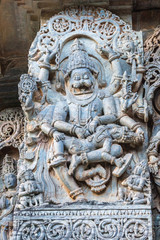 Fototapeta na wymiar Halebidu, Karnataka, India - November 2, 2013: Hoysaleswara Temple of Shiva. Closeup of statue on side of main sanctuary, where Narasiṃha, Vishnu avatar, kills Hiraṇyakasipu, in bluish gray stone.