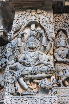 Halebidu, Karnataka, India - November 2, 2013: Hoysaleswara Temple of Shiva. Closeup of statue on side of main sanctuary, where Narasiṃha, Vishnu avatar, kills Hiraṇyakasipu, in bluish gray stone.