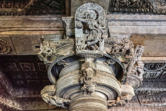 Halebidu, Karnataka, India - November 2, 2013: Hoysaleswara Temple of Shiva. Closeup of Madanakai or Salabhanjika, a dancing girl statue against ceiling on top of pillar. Gray brownish stone.