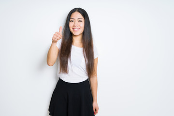 Obraz premium Beautiful brunette woman over isolated background doing happy thumbs up gesture with hand. Approving expression looking at the camera with showing success.
