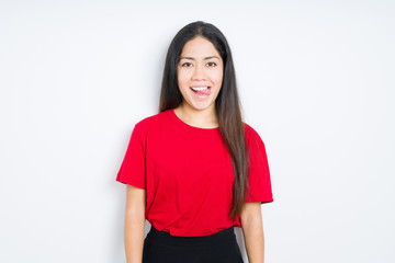 Beautiful brunette woman wearing red t-shirt over isolated background sticking tongue out happy with funny expression. Emotion concept.