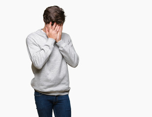 Young handsome sporty man wearing sweatshirt over isolated background with sad expression covering face with hands while crying. Depression concept.