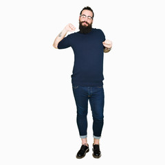 Naklejka premium Young hipster man with long hair and beard wearing glasses stretching back, tired and relaxed, sleepy and yawning for early morning