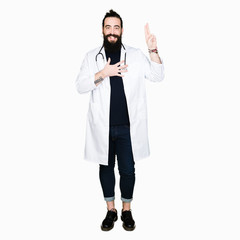 Doctor with long hair wearing medical coat and stethoscope Swearing with hand on chest and fingers,...