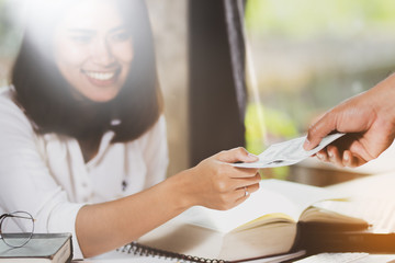 Fototapeta premium Asia woman receive paper from someone and smiles with happy.