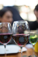 red wine glasses infront of young adult couple