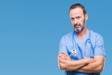 Middle age hoary senior doctor man wearing medical uniform over isolated background skeptic and...