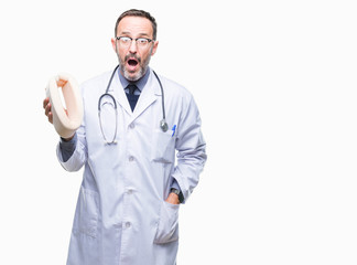 Middle age senior hoary doctor man holding neck collar over isolated background scared in shock with a surprise face, afraid and excited with fear expression