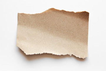 Brown corrugated texture paper torn on white background. rip of cardboard sheet used as a...