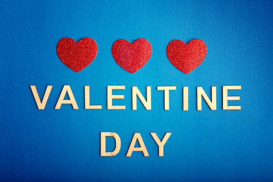 Happy Valentine Day. Beautiful card wallpaper with three red hearts in centre on blue background. Gradient toned backdrop. Concept of polygamy love and February holiday.
