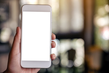Mockup image of a hand holding and showing a white mobile phone with blank screen with blurred background in cafe