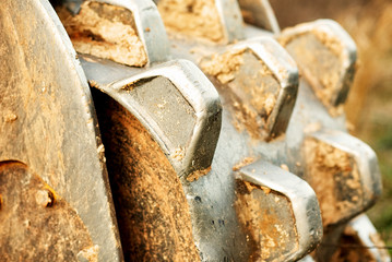 A rolling compactor on the back of a bucket on a large track hoe.