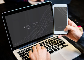Businessman using a laptop and a mobile phone mockup