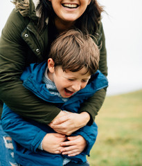 Fototapeta premium Cheerful mother embracing her son