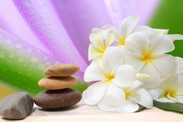 Naklejka na ściany i meble Zen spa concept background - Zen massage stones with frangipani plumeria flower