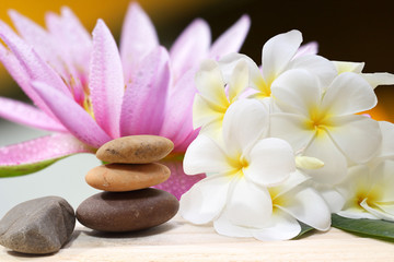 Obraz na płótnie Canvas Zen spa concept background - Zen massage stones with frangipani plumeria flower