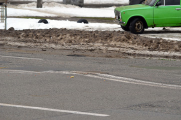 Poor condition of the road surface. Winter season. Wet and foggy weather. Residential area  of Kiev. 