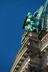 Fototapeta na wymiar Angel statue on top of a church with blue sky background