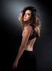 Fototapeta na wymiar young beautiful Hispanic woman is wearing a tight sexy black dress and has nice long black hair