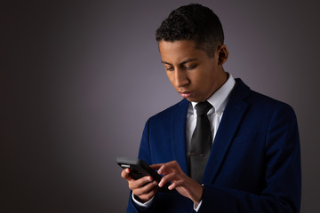 Hispanic Teenager Dressed Well Dressed in Suit, and Using Cellphone, Smartphone