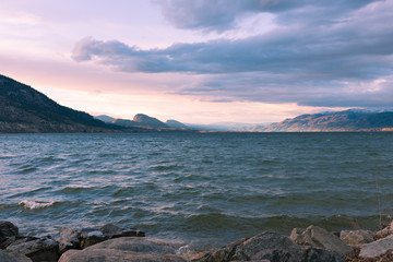 Plakat Storm clouds and waves on lake at sunset with view of mountains