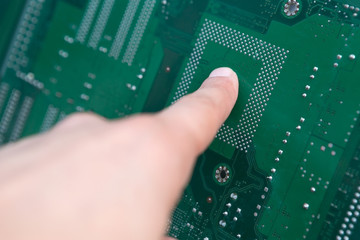 Human Finger Touching a Digital Motherboard Chip