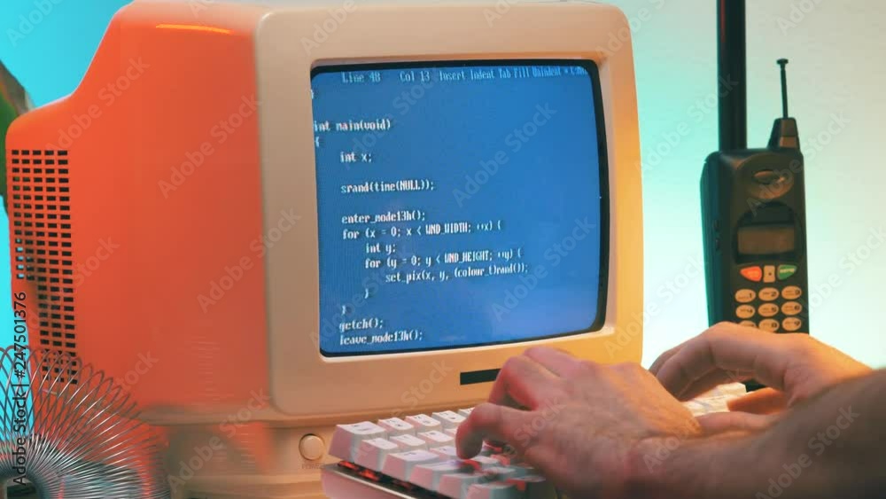 Wall mural using a vintage computer from the late 80s early 90s to work on a desk. retro screen and background.