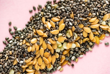 Healthy superfood:  flax seeds, chia seeds and hemp shelled seed on pink background