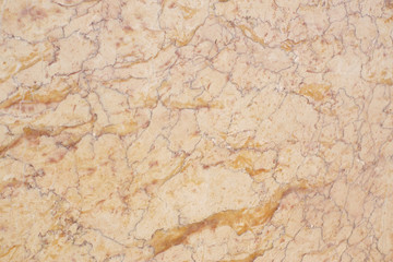 The delicate surface of a yellow natural stone with red stripes is called Crema Valencia