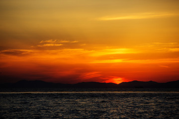 Obraz premium Beautiful bright sunset on the sea. A lone boat and yacht drift in the background of the sunset.