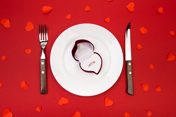Box witha ring, table setting on a red background. Concept Valentine's Day. - Image