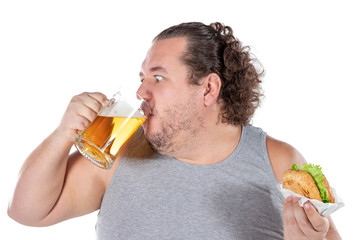 Fototapeta premium Funny fat man eating burger and drinking alcohol beverage on white background