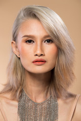 Asian Woman before applying make up silver gray hair style. no retouch, fresh face with lips, eyes, cheek, nice smooth skin. Studio lighting beige yellow background, for aesthetics therapy treatment