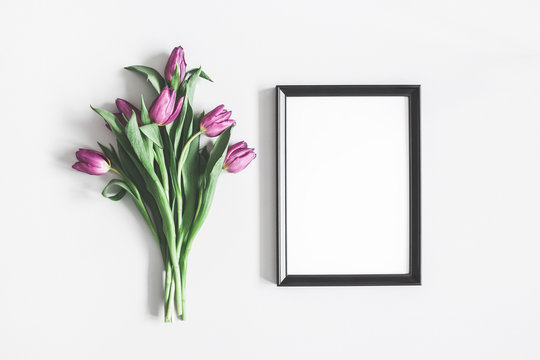 Flowers composition. Purple tulip flowers, photo frame on pastel gray background. Valentines day, mothers day, womens day, spring concept. Flat lay, top view, copy space