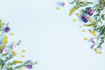 Flowers composition. Yellow and purple flowers on pastel blue background. Spring, easter concept. Flat lay, top view, copy space - 247511582