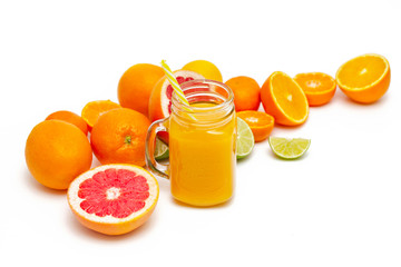 Freshly blended yellow and orange fruit smoothie in glass jar. Glass jar mugs with orange health smoothie, lime, grapefruit, lemon, tangerine. Selective focus. Copy space. Vegetarian food concept.  