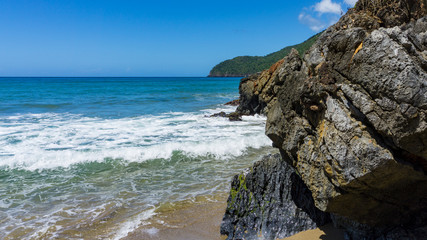Fototapeta na wymiar Ein Strand mit Felsen und Wellen in Punta Cana, Atlantik, nördlich des Äquators