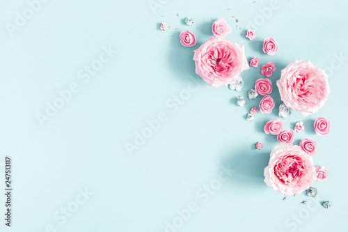 Flowers composition. Frame made of rose flowers on pastel blue background. Valentines day, mothers day, womens day, spring concept. Flat lay, top view, copy space