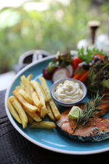 Roasted salmon steak , baked salmon with salad fresh vegetable pm wooden table