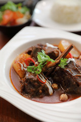 Beef massaman curry with rice and salad on wooden background , Thai food