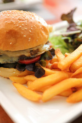 Beef Hamburger  with fries and salad on wooden background