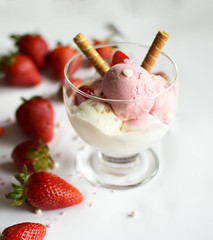 A cup of ice cream with strawberries and rolled wafers. ice cream closeup.