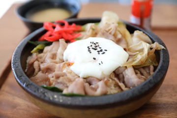 Japanese food Gyudon Japanese beef on rice bowl topped with egg on wooden table