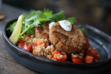salmon fishcakes with oat and salad on wooden table