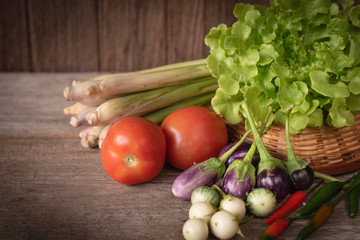 Various fresh, young homegrown vegetables, tomato, lemon grass, chilli,  lettuce, Eggplant place on a wooden table