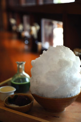 Delicious Japanese sweet shaved ice green tea on wooden table in japanese cafe