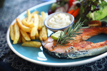 Roasted salmon steak , baked salmon with salad fresh vegetable pm wooden table