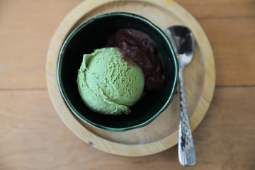 Japanese green tea ice cream with red bean topping on wooden table in coffee shop