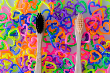 Two toothbrushes on colorful mini  heart toy plastic